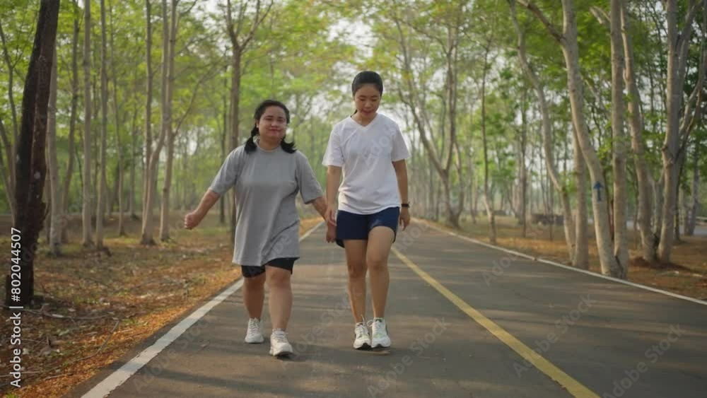 Happy young Asian female friends doing their morning exercise together at a local park, stretching and running Happy young Asian female friends doing their morning exercise together at a local park, stretching and running