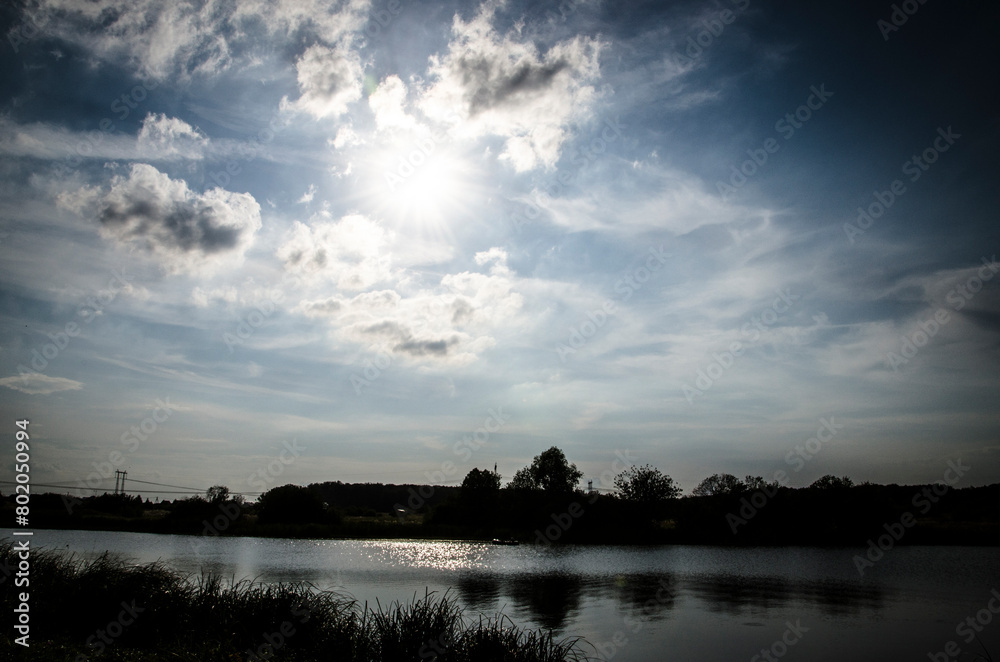 Fototapeta premium Dramatic sky with clouds over the river. Nature composition.