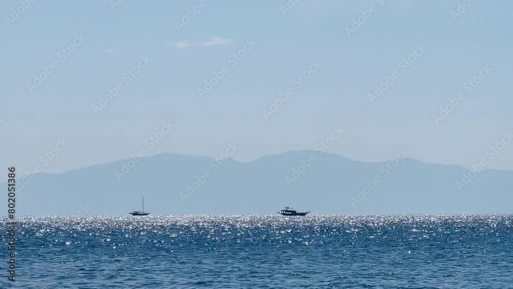 Sparkling sea with distant mountains under a sunny sky dotted with clouds, summer holiday travel. High quality 4k footage Sparkling sea with distant mountains under a sunny sky dotted with clouds, summer holiday travel. High quality 4k footage