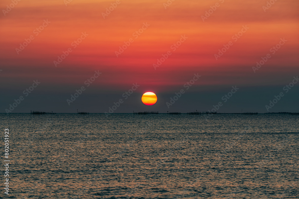 Sunset over the sea background. Big sun over the sea with beautiful natural light at sunset or sunrise.