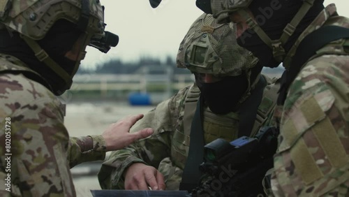 Soldiers pointing and looking at map