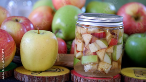 Homemade apple vinegar in a jar made from fresh chopped apples and soaked in sugar water.