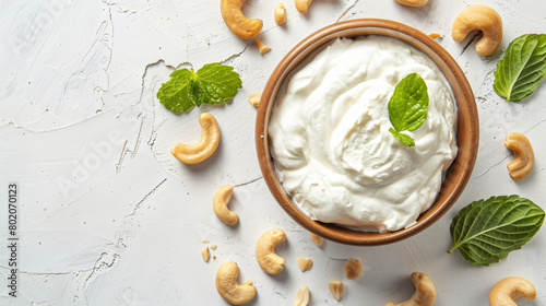 Bowl of sour cream with cashew nuts on light background photo