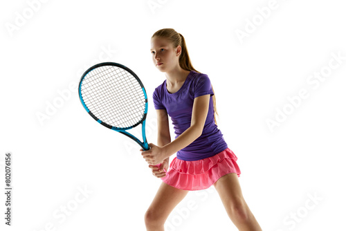 Portrait of young athletic teenage girl in vibrant uniform stand ready to start tennis game against white studio background. Concept of professional sport, movement, tournament, action. Ad