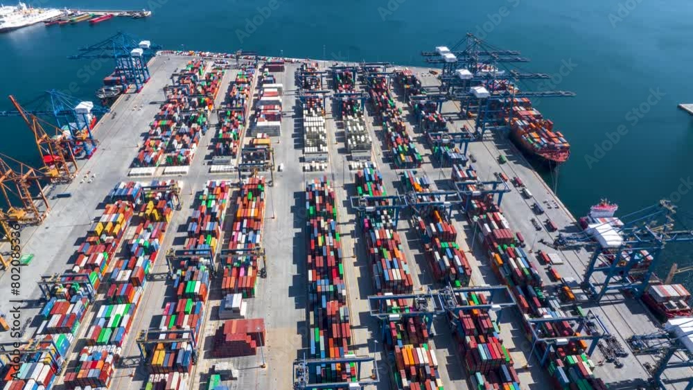 Aerial hyper lapse view of a industrial cargo container terminal with loading and unloading activity