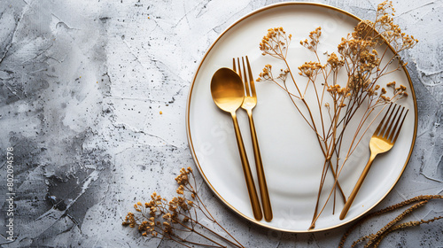 Clean plate with golden cutlery and dried lagurus photo