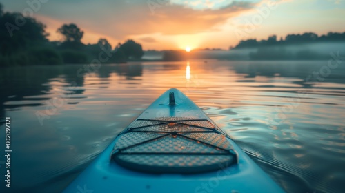 A close-up of a paddleboard on calm lake waters at dawn. photo
