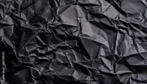 Black crumpled paper texture background with empty space for text