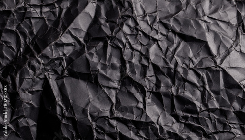 Black crumpled paper texture background with empty space for text