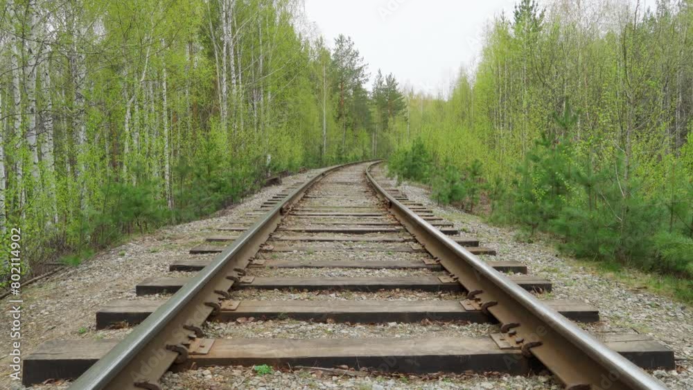 A railway passing through the forest. Old railway tracks. Railway rails on wooden sleepers. A railway passing through the forest. Old railway tracks. Railway rails on wooden sleepers.