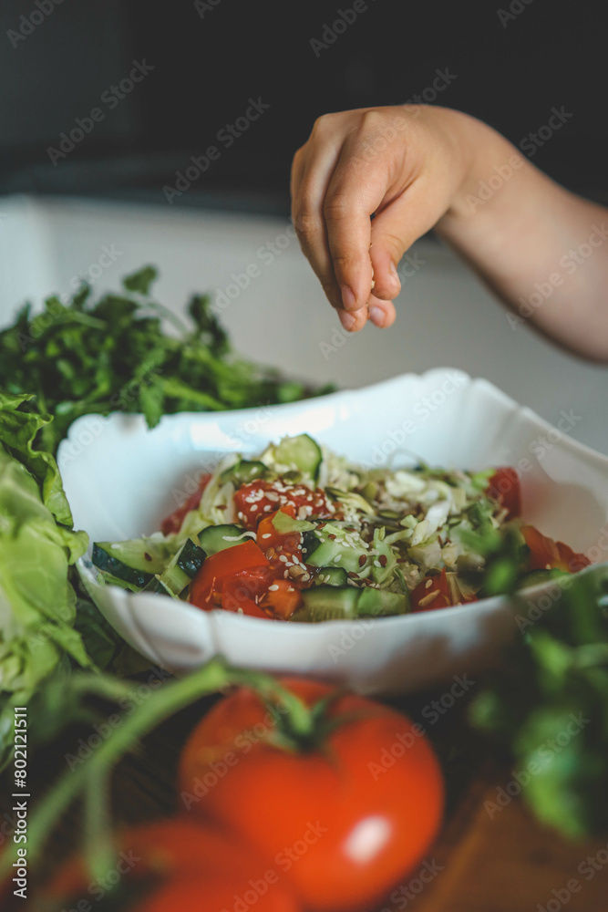 Preparing vegetable salad, sprinkle flax and sesame seeds Preparing vegetable salad, sprinkle flax and sesame seeds