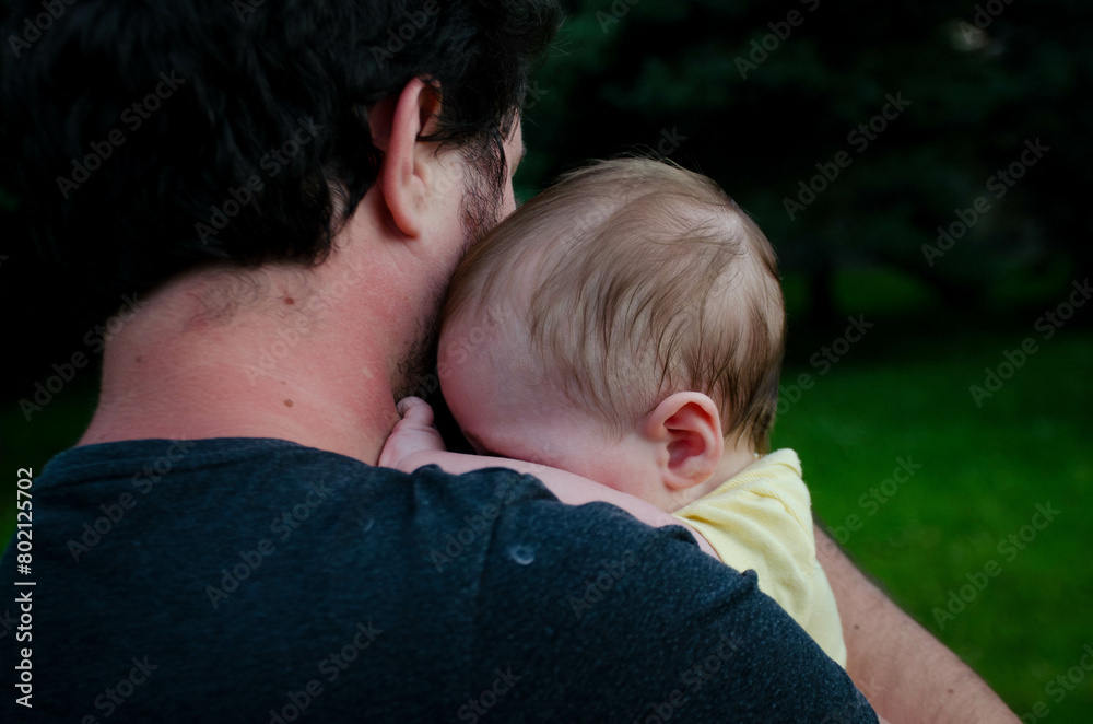 Fototapeta premium Bébé qui se cache dans les bras de son papa
