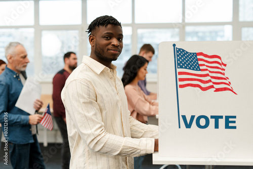 Fotografia Attractive smiling African American man voter standing in election booth voting