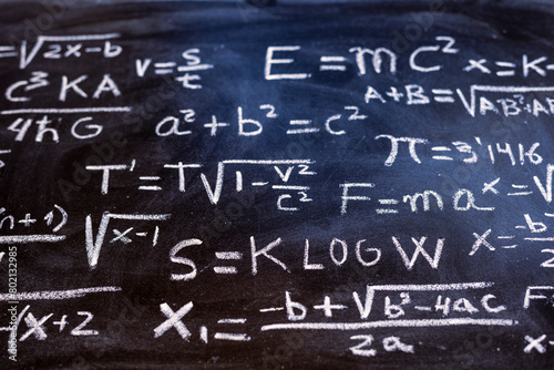 Operaciones matemáticas y formulas de física cuántica escritas con una tiza en la pizarra 