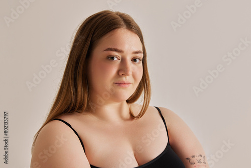 Foto Portrait of beautiful cubby girl looking at camera against grey studio background