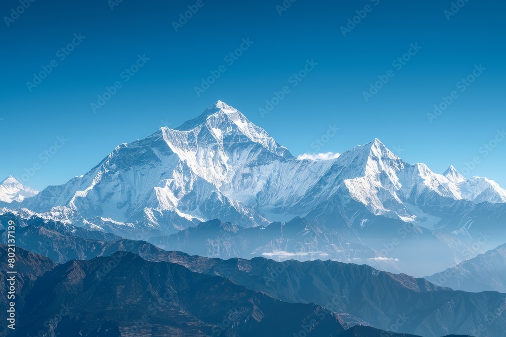 A view from above of a snowcapped mountain range under a clear blue sky, showcasing the vastness and grandeur of the landscape