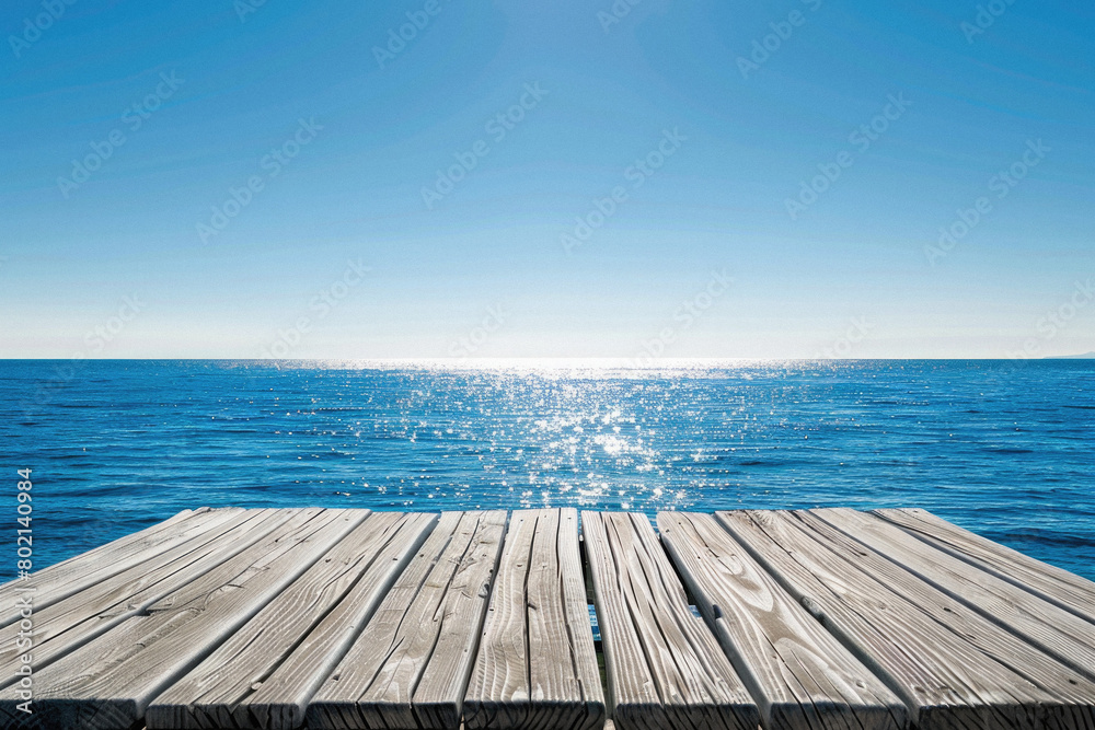 A wooden pier overlooking the ocean with a clear blue sky