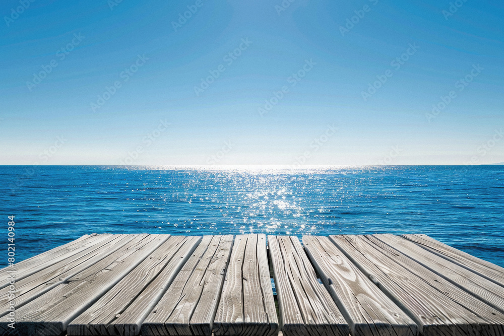 A wooden pier overlooking the ocean with a clear blue sky A wooden pier overlooking the ocean with a clear blue sky