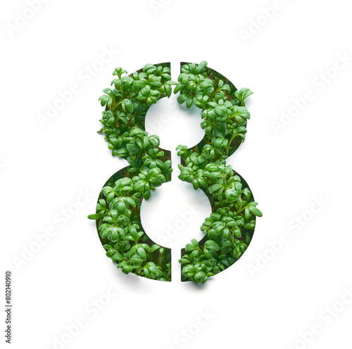 Number eight is created from young green arugula sprouts on a white background.