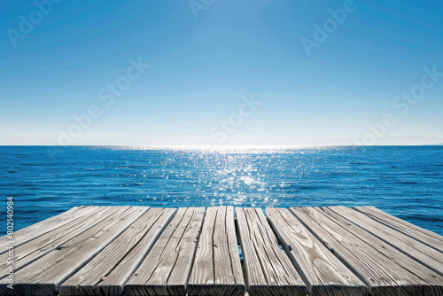 A wooden pier overlooking the ocean with a clear blue sky