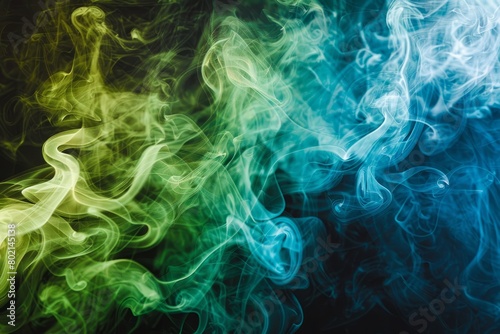 Colorful green and blue smoke billows gracefully against a black backdrop with soft lighting enhancing the vibrant colors photo