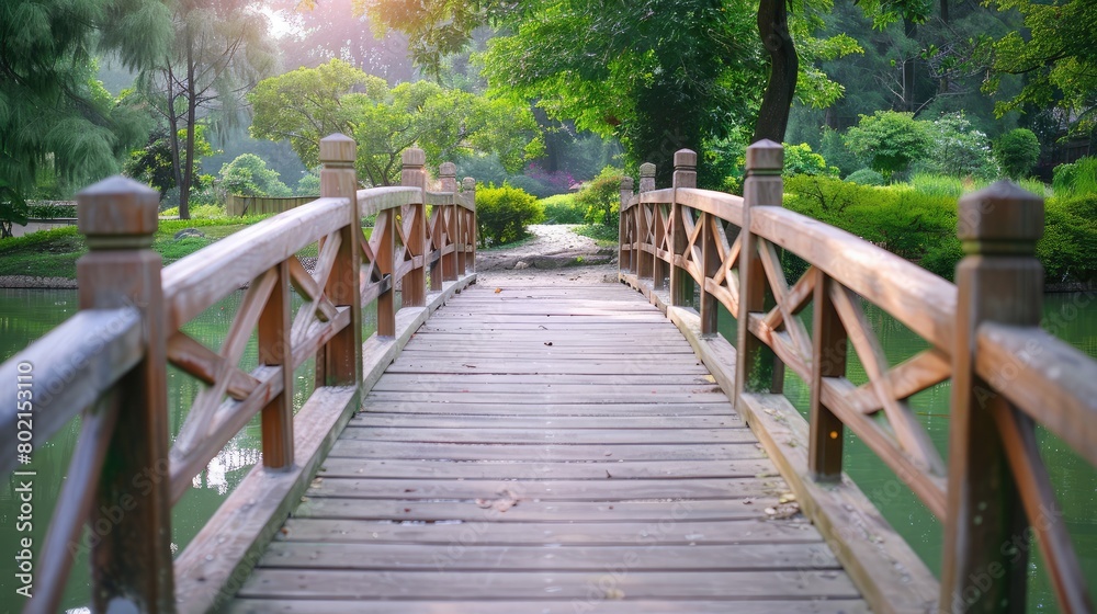 Obraz premium Wooden pedestrian bridge over a serene pond in a Japanese garden, embodying tranquility and Zen aesthetics.