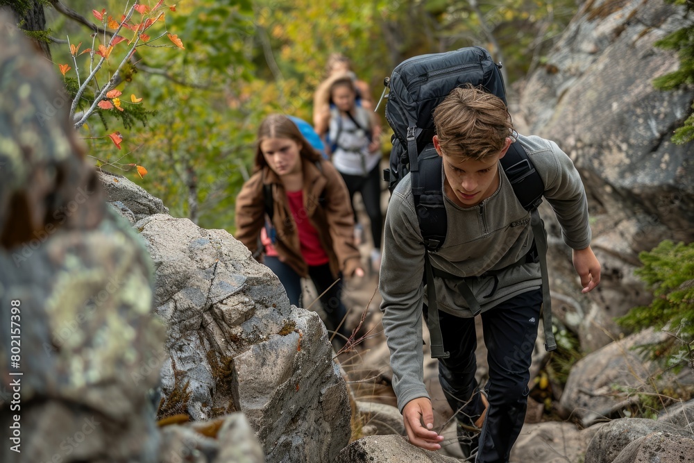 Teenagers showcasing determination and adventurous spirit while hiking up a rocky trail