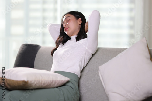 Happy asian woman relaxing on couch comfortable in the living room, spending lazy weekend.