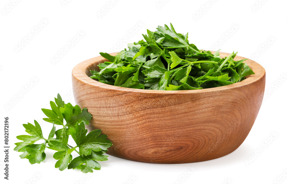 Parsley chopped into a wooden plate and leaves on a white background. Isolated
