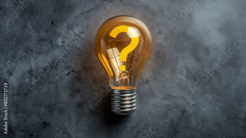 A glowing light bulb with a question mark filament against a textured gray background, symbolizing curiosity and ideas.