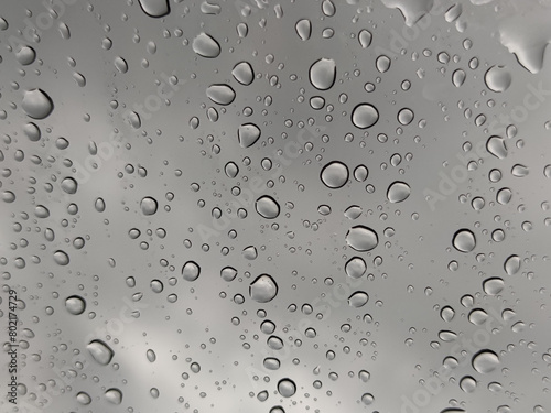 Water Rain Droplets Drops on Car Glass Window with Gray Sky Background