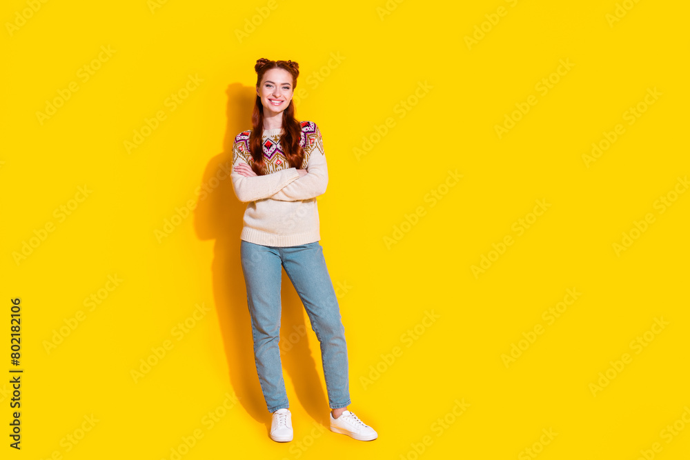 Photo portrait of attractive young woman crossed hands confident dressed stylish knitted warm outfit isolated on yellow color background Photo portrait of attractive young woman crossed hands confident dressed stylish knitted warm outfit isolated on yellow color background