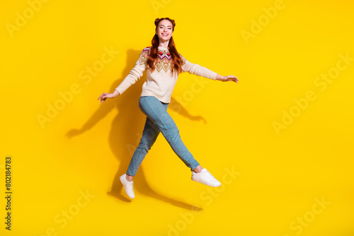Photo portrait of attractive young woman jumping walk dressed stylish knitted warm outfit isolated on yellow color background
