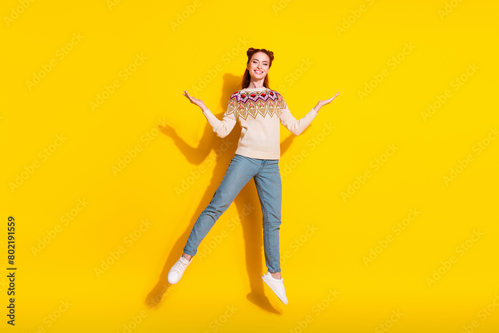 Photo portrait of attractive young woman jump raise hands dressed stylish knitted warm outfit isolated on yellow color background