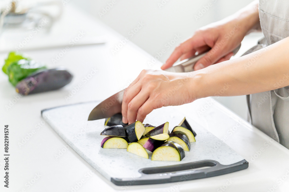 Obraz premium 包丁で野菜を切る女性の手元・料理イメージ