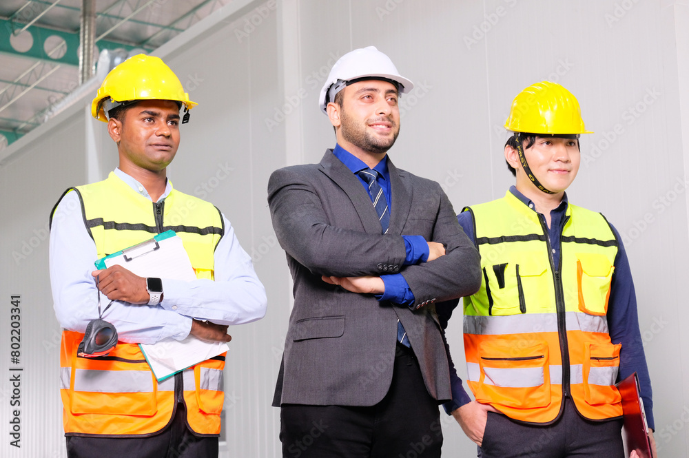 Engineers and employees wear safety helmets working inside the factory.