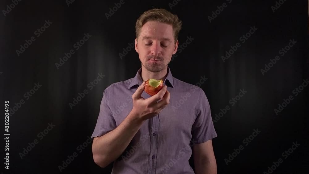 Captivating portrait of a stylish young man with stubble, donning a vibrant purple shirt on a sleek black backdrop, takes bites of meal, exuding an effortless cool vibe. Lifestyle, fashion or culinary Captivating portrait of a stylish young man with stubble, donning a vibrant purple shirt on a sleek black backdrop, takes bites of meal, exuding an effortless cool vibe. Lifestyle, fashion or culinary
