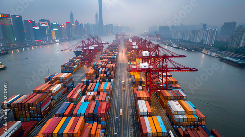 Aerial view of a busy port with stacked containers and cranes during early morning in Shanghai