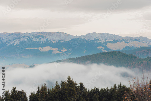 A majestic mountain range is shrouded in a blanket of swirling clouds  creating a mystical and enchanting scene in nature