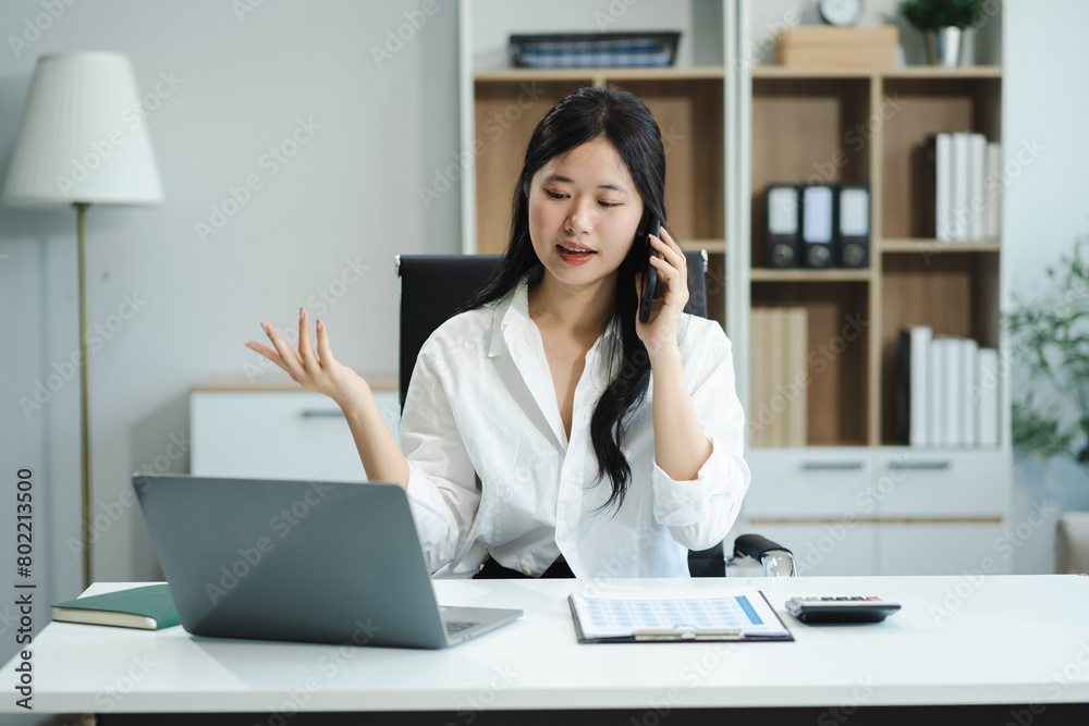 Businessman using laptop computer and smartphone in office. Happy woman, entrepreneur, small business owner working online. Businessman using laptop computer and smartphone in office. Happy woman, entrepreneur, small business owner working online.