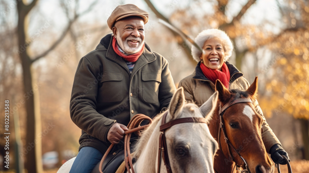 Obraz premium Elderly happy couple riding horses in the park
