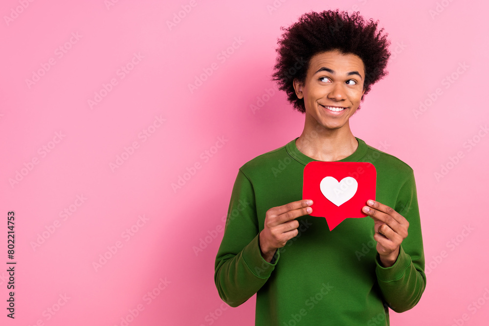 Photo of happy positive guy hold heart like look empty space isolated pastel color background Photo of happy positive guy hold heart like look empty space isolated pastel color background