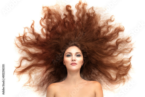 A young beautiful brunette woman with scattered long luxurious hair on a white background.