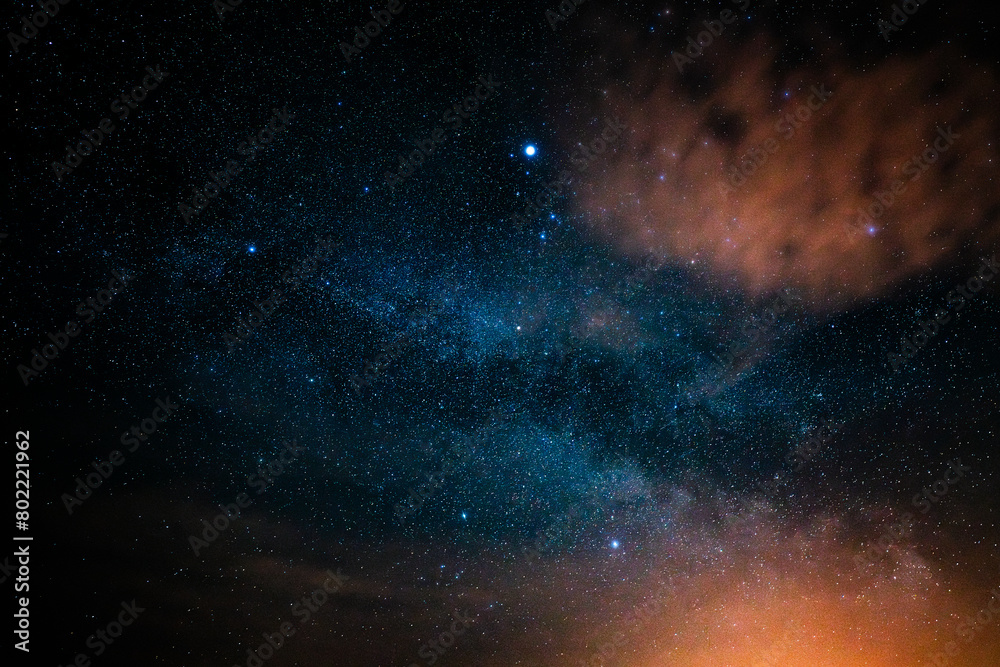 Fototapeta premium Milky way in the night sky. Long exposure with constellations. Cloud with sahara dust at the edge of the image. Weather phenomenon photographed in spring.