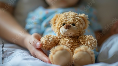 Little hand holding teddy bear, comfort in hospital, close up, symbol of bravery, warm hues -