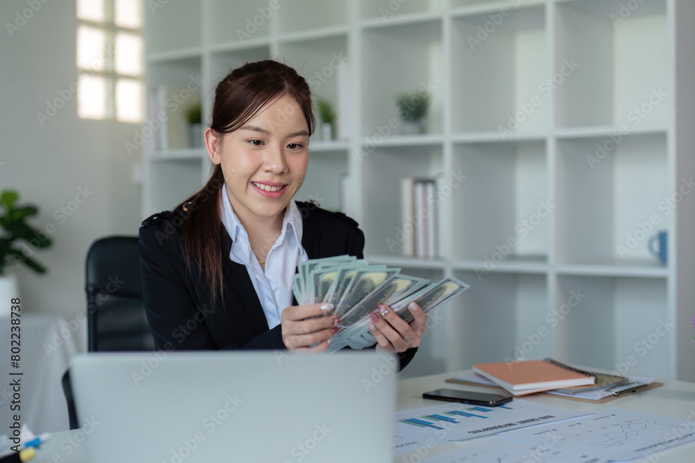 Businesswoman or financial bookkeeper holding bundle of money dollar for payment salary and income. entrepreneur counting money cash count salary profit finance at office Businesswoman or financial bookkeeper holding bundle of money dollar for payment salary and income. entrepreneur counting money cash count salary profit finance at office