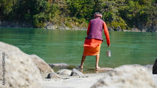a monk stands in river of rishikesh