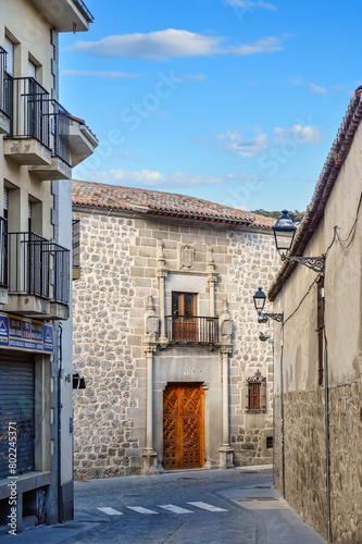 Narrow city street leading to Palacio de los Verdugos (1531) in Avila, Spain