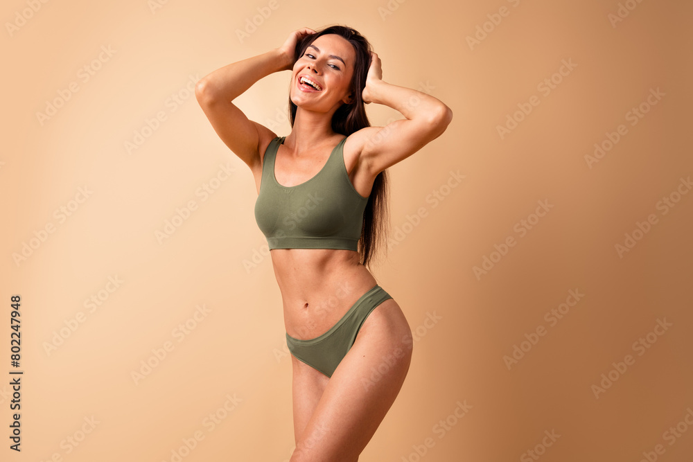 Obraz premium Photo portrait of pretty young girl touch hair laughing posing no retouch wear trendy khaki lingerie isolated on beige color background