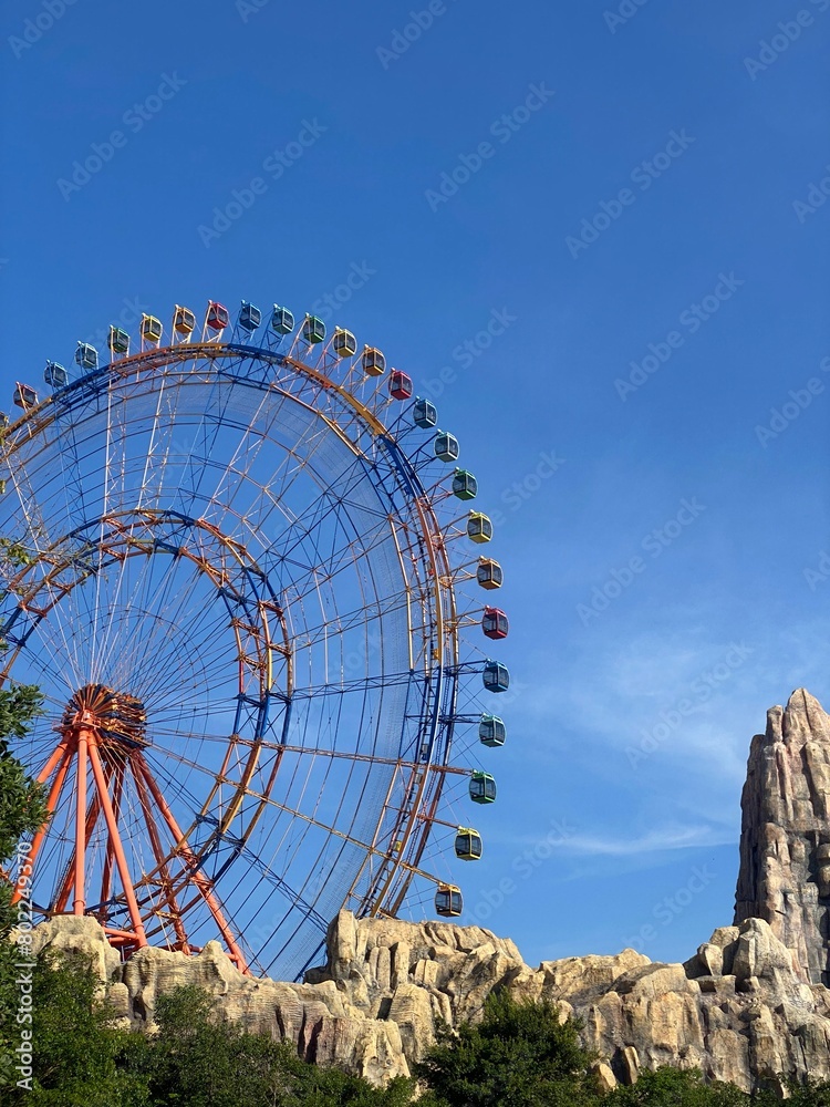 Fototapeta premium A ferris wheel with blue sky in theme park
